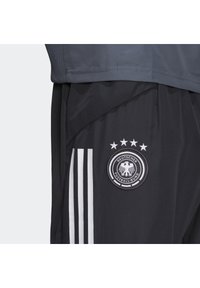 Sorte sportsshorts lavet af letvægtsstof, med tre hvide striber og et rundt logo med en ørn og fem stjerner.
