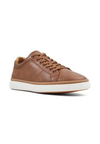 Zapatillas de cuero marrón con textura suave, punta redonda y suela de goma blanca. Cuentan con cierre de cordones y detalles de costura mínimos.
