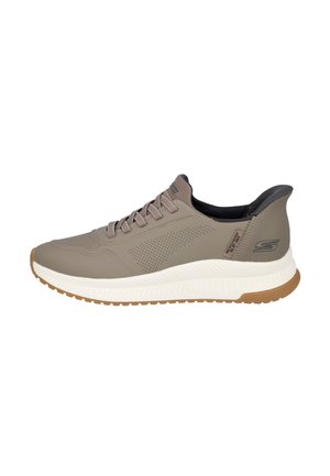 Zapatilla deportiva de hombre en color topo con cordones, suela blanca, dibujo marrón, lateral perforado y cuello acolchado negro.