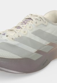 Бяла и сива маратонка Adidas с текстурирана материя, три сиви ивици отстрани, бели връзки и светлокафява подметка с етикет "LIGUSTRUM PRO."