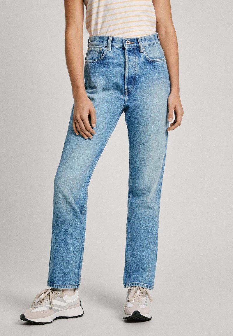 Jeans de talle alto en azul claro con diseño de pierna recta, que cuentan con bolsillos frontales, cierre de botón y un ligero desvanecimiento en la tela.