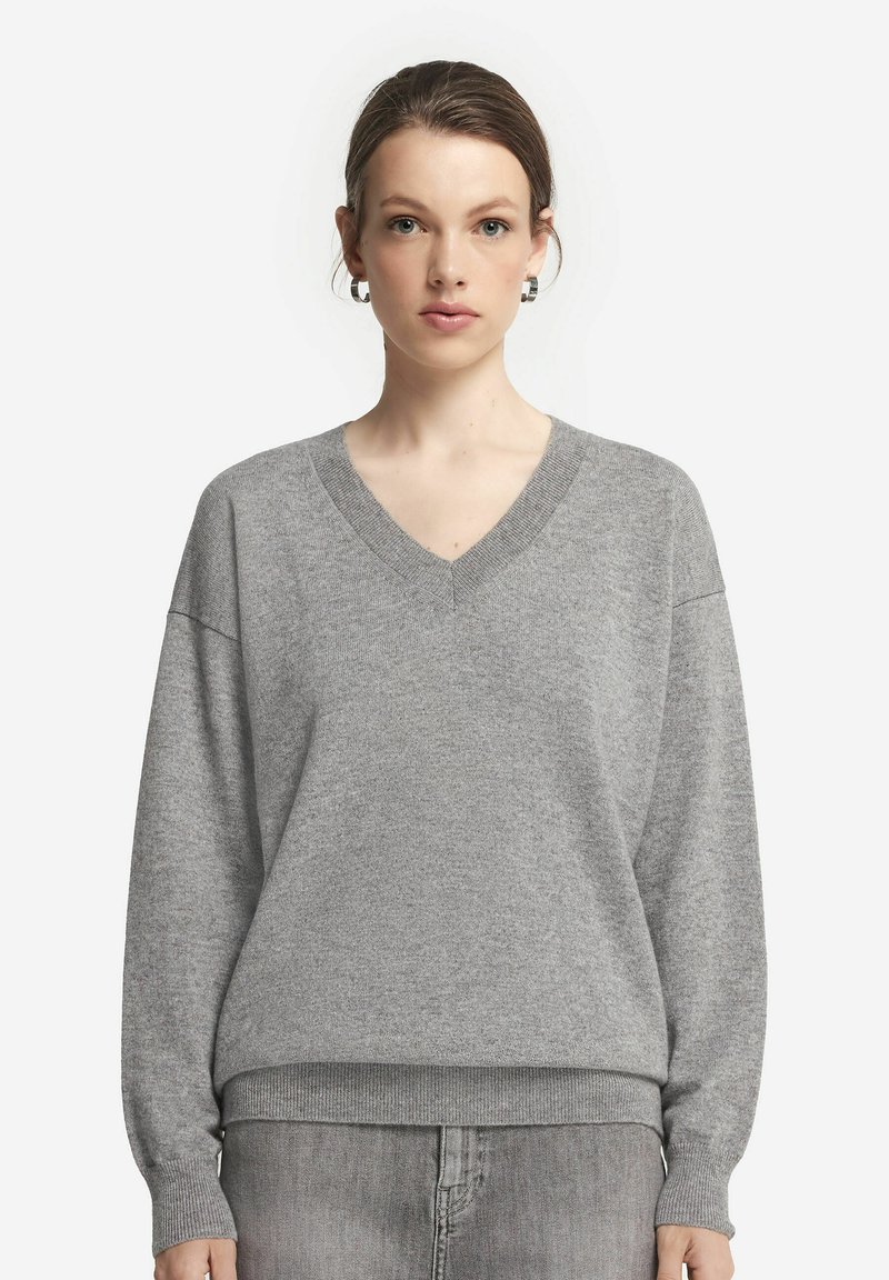 Szary dzianinowy sweter z dekoltem w serek, opadłymi ramionami i prążkowanym dołem. Miękka tekstura i luźny krój zapewniają komfort.