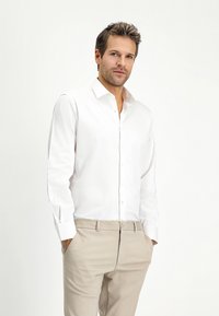 Witte lange mouw button-up shirt van katoen, met een klassieke kraag en gestikte manchetten, gecombineerd met beigebroek.