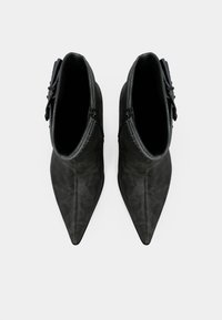Black leather ankle boots with a pointed toe, smooth texture, subtle stitching detail, and a side zipper for closure.