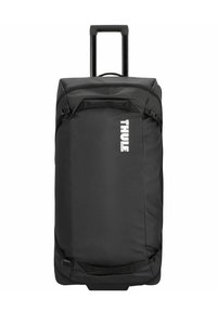Black rolling duffel bag with sturdy handle, zippered main compartment, and adjustable side straps. Features prominent white "THULE" logo.