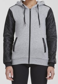 Sudadera gris con cremallera y mangas acolchadas negras. Cuenta con una capucha ajustable, dos bolsillos laterales y puños y dobladillo acanalados.