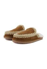 Pantofole in suede marrone con una morbida foderatura in pelliccia bianca e bordo intrecciato a contrasto; suola piatta con grip testurizzato. Design a punta rotonda.