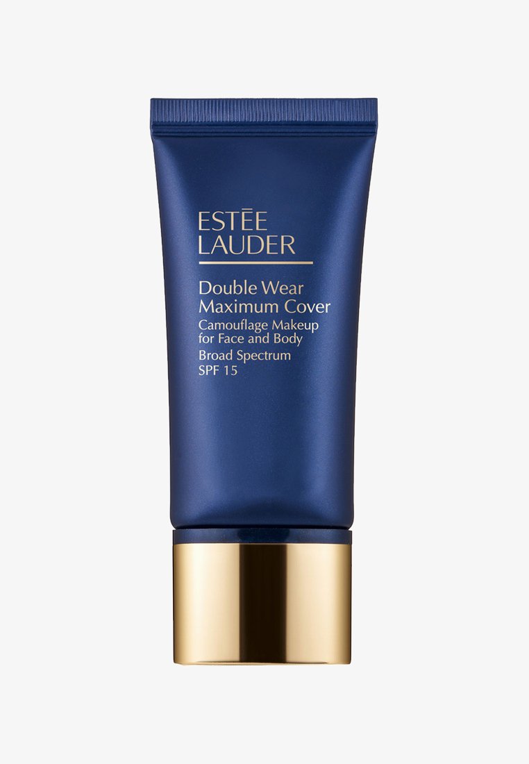 Tube bleu marine avec accent doré ; étiqueté "Double Wear Maximum Cover." Maquillage camouflage pour le visage et le corps, FPS 15, large spectre.