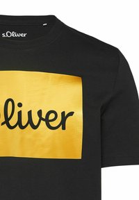 Schwarzes Baumwollt-Shirt mit einem großen, glänzenden gelben rechteckigen Logo, auf dem "s.Oliver" in fettem, schwarzem Schriftzug gedruckt ist.