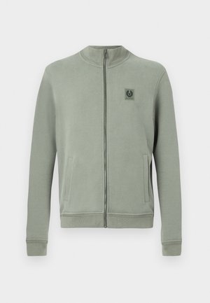 Light green zip-up sweatshirt, made of soft fabric. Features a high collar, front pockets, and a small logo patch on the chest.