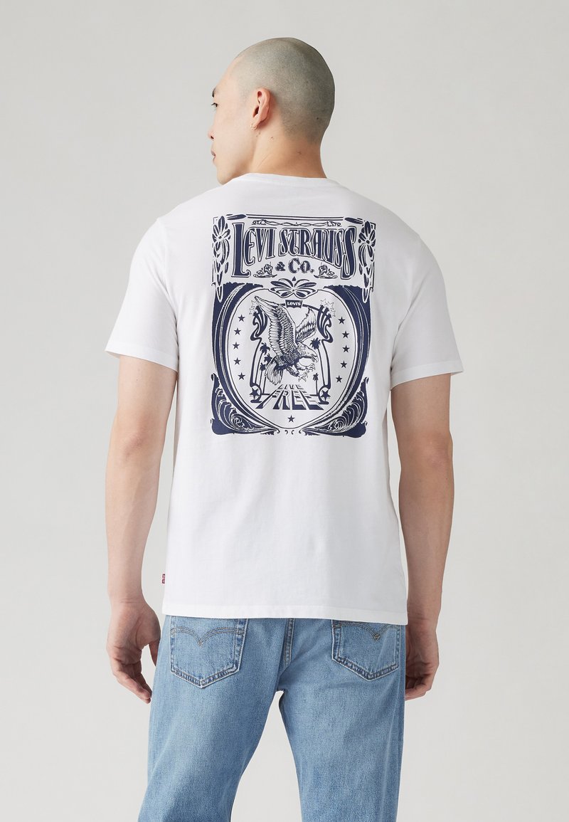 Tricou alb cu maneci scurte, având un grafic albastru pe spate cu un design de vultur și textul "Levi Strauss & Co.". Material din bumbac moale.