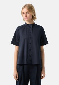 Navy blue short-sleeve shirt with a stand collar, front button closure, and smooth fabric texture. Simple, clean design with no patterns.
