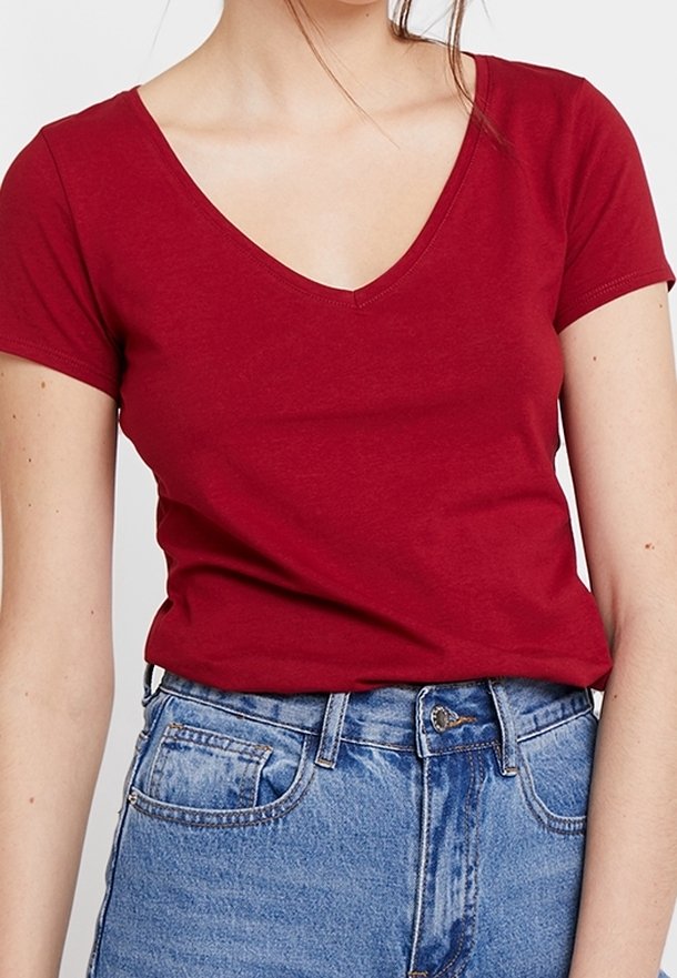 Red short-sleeve T-shirt with a deep V-neck design, made of soft cotton material, paired with high-waisted blue denim jeans.