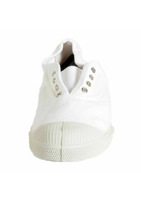 Sneaker en toile blanche avec semelle en caoutchouc, caractérisée par des oeillets en ton argenté, un bout texturé et un design bas, facile à enfiler.
