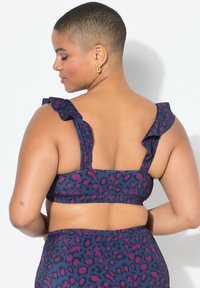 Dvoudílný plavkový set s leopardím potiskem v modrých, fialových a růžových barvách. Volánkové ramínka a hladký materiál, navržený pro pohodlí a oporu.