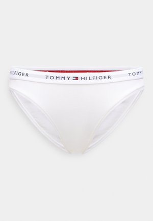 Fehér pamut fehérnemű márkás gumírozott derékrésszel, piros és kék díszítésekkel. Sima textúrájú, klasszikus férfi alsónadrág dizájn.