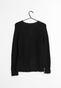 Pull noir en maille à manches longues avec col rond, suspendu sur un cintre noir contre un fond blanc.