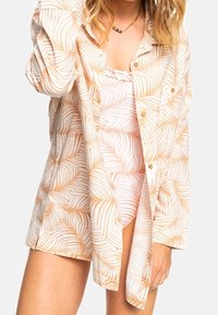Leichte, cremefarbene Hemdbluse mit orangefarbenem Palmenblättermuster. Lockere Passform, lange Ärmel, leicht strukturiertes Material und ein lässiges Design.