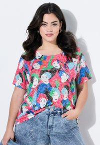 Kortærmet T-shirt med et farverigt print af illustrerede ansigtstræk i pink, blå og grøn på struktureret stof, rund halsudskæring.