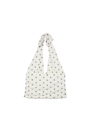 Bijeli halter top s crnim točkicama, skupljenim detaljem tkanine i remenčićima vezanim oko vrata.