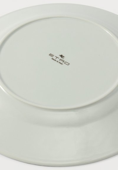 Assiette en céramique blanche retournée, présentant le logo "ETRO Made in Italy" et un petit emblème de cheval ailé au centre de la base.