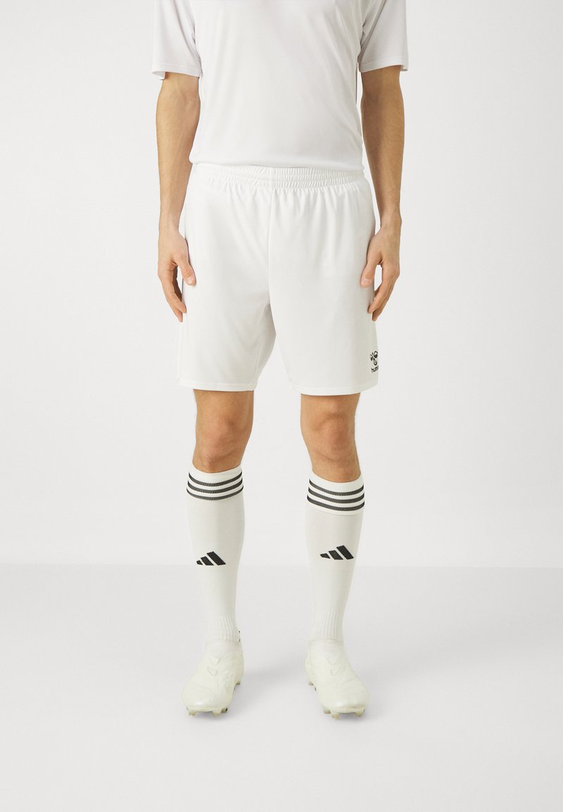 Weiße Fußballshorts und Socken mit drei schwarzen Streifen oben, getragen mit hellen Fußballschuhen. Einfaches Design, Sportmaterial.