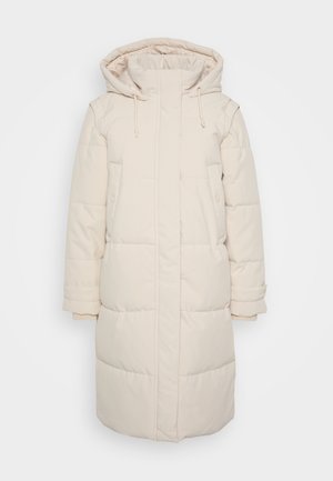 Lunga giacca puffa crema con cappuccio, chiusura frontale con zip, due tasche laterali e polsini elastici. Il tessuto appare liscio e isolato.