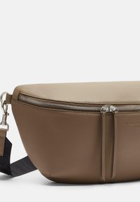 Brązowa skórzana torba na ramię o gładkim wykończeniu, z zamkiem błyskawicznym na górze i odpinanym paskiem, z minimalistycznymi akcentami.