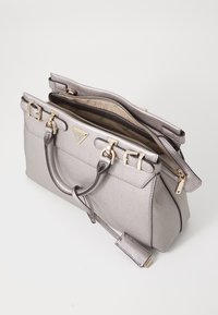 Borsa a mano in argento metallico con design strutturato, doppi manici e hardware dorato. Presenta due scomparti con zip e un accento con logo.
