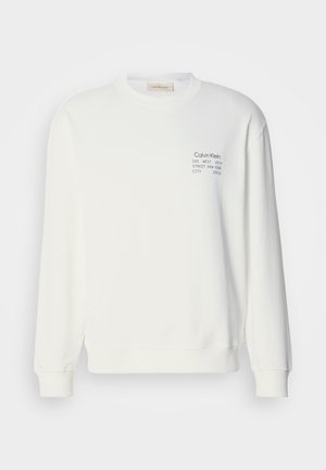 Balta medvilninė sweatshirta su ilgomis rankovėmis, apvaliu kaklu ir spaudiniu ant krūtinės, turinti įaugusias rankoves ir apykaklę.