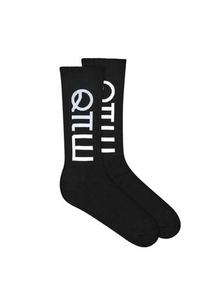 Czarne skarpety za kostkę z pionowym białym napisem, zawierającym stylizowaną literę „Q” oraz litery „UILM” po boku.