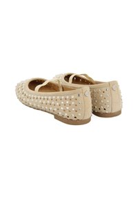Ballerine in suede beige con cinturino posteriore, decorate con borchie argentate, punta tonda e suola bassa marrone.