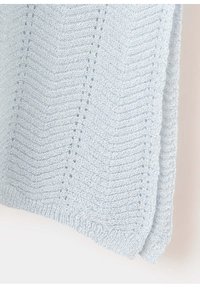 Tissu tricoté bleu clair avec un motif en chevrons et de petites rangées de points ouverts, présenté sur un fond clair uni.