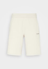Cremfarbene Baumwollshorts mit einem Kordelzugbund, zwei seitlichen Taschen und einem kleinen gestickten Logo am unteren linken Bein.