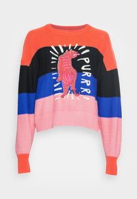 Kleurrijke cropped trui van gebreide stof met gedurfde strepen in oranje, roze, blauw en zwart, met een afbeelding van een roze tijger en tekst.