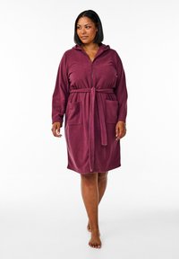 Burgundy zip-up morgonrock gjord av mjukt fleece-tyg, med huva, midjeband och två framfickor, lång ärm och knälång längd.
