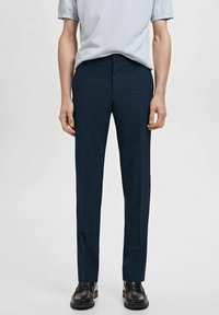 Marineblaue, maßgeschneiderte Hose mit geradem Schnitt, glattem Stoff, vorderer Bügelfalte und Gürtelschlaufen, kombiniert mit einem hellblauen Kurzarmoberteil.