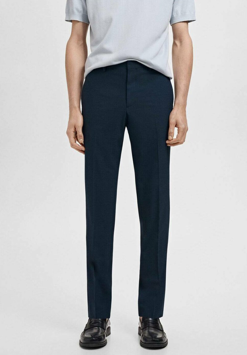 Marineblaue, maßgeschneiderte Hose mit geradem Schnitt, glattem Stoff, vorderer Bügelfalte und Gürtelschlaufen, kombiniert mit einem hellblauen Kurzarmoberteil.