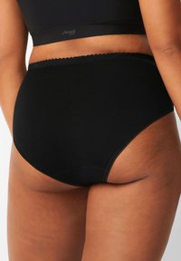 Mutande nere a vita alta con texture liscia, caratterizzate da un bordo decorativo in pizzo in vita e un design senza cuciture.