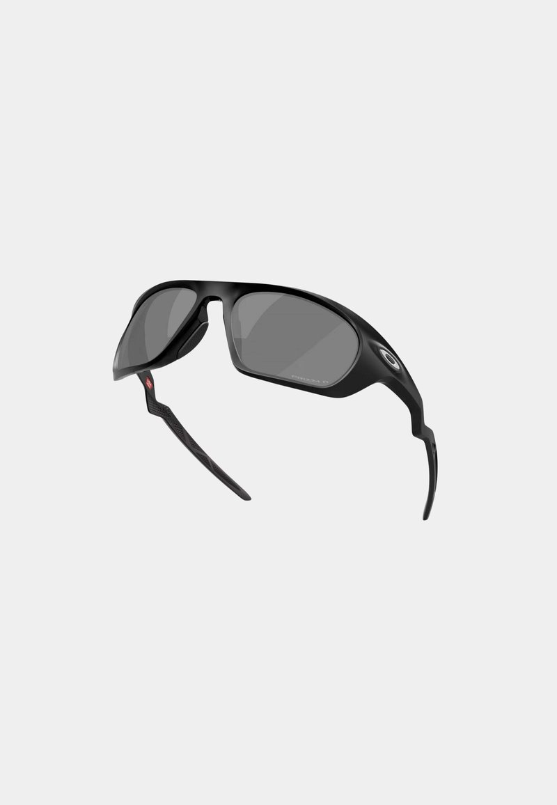 Lunettes de sport noires au design incurvé, verres gris, branches flexibles et accents texturés sur les branches pour une meilleure prise en main.