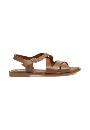 Sandal de cuero marrón con correas cruzadas, hebilla ajustable en el talón, suela plana y plantilla texturizada. Diseño minimalista con detalles de costura.