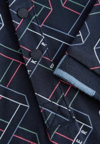 Korte mouwen marineblauw shirt met geometrisch patroon in rood, groen en wit. Voorzien van zwarte knopen en gestructureerde kraagdetails.