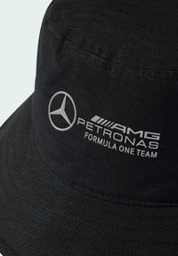 Black bucket hat made of textured fabric, featuring a silver Mercedes logo and "AMG PETRONAS Formula One Team" branding on the front.