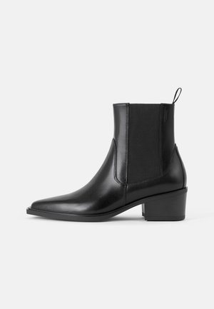 Black leather ankle boot with sleek design, pointed toe, elastic side panels, and a low block heel. Textured finish with pull tab detail.