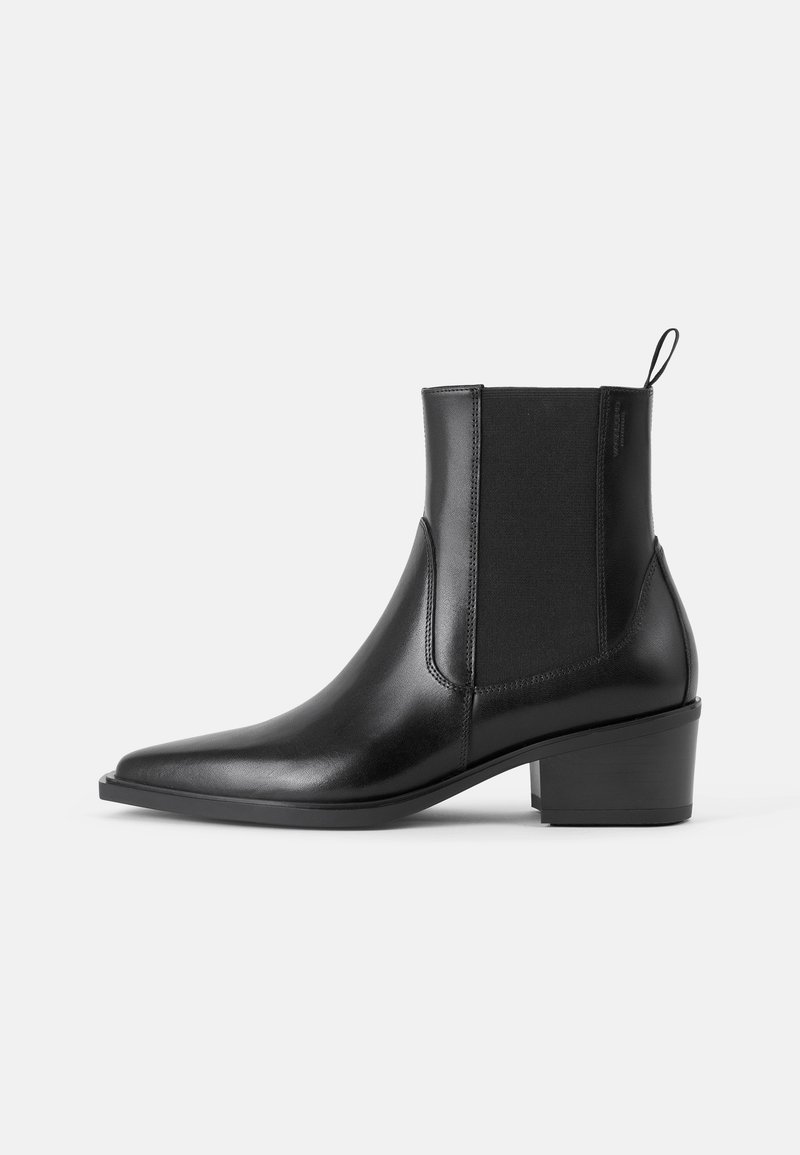 Bottines noires en cuir au design épuré, à bout pointu, avec des panneaux latéraux élastiques et un talon bas carré. Fini texturé avec détail de tirage.