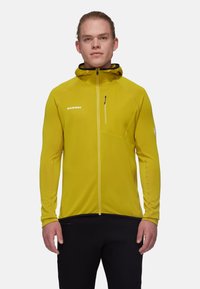 Herrjacka i gult från Mammut med huva som kan dras åt med dragkedja, strukturerad tyg, slim fit och en bröstficka med dragkedja. Har en reflekterande logotypdetalj.