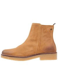 Stivale alla caviglia in suede tan con punta arrotondata, tacco impilato e pannelli elastici laterali. Presenta cuciture a contrasto e una suola in gomma.