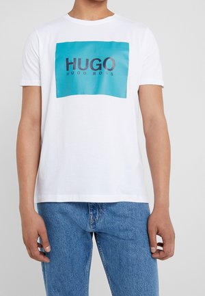 Weißes Baumwoll-T-Shirt mit einem großen türkisfarbenen rechteckigen Grafikdruck, auf dem der Text "HUGO HUGO BOSS" in Schwarz zu sehen ist, kurzen Ärmeln und einem Rundhalsausschnitt.