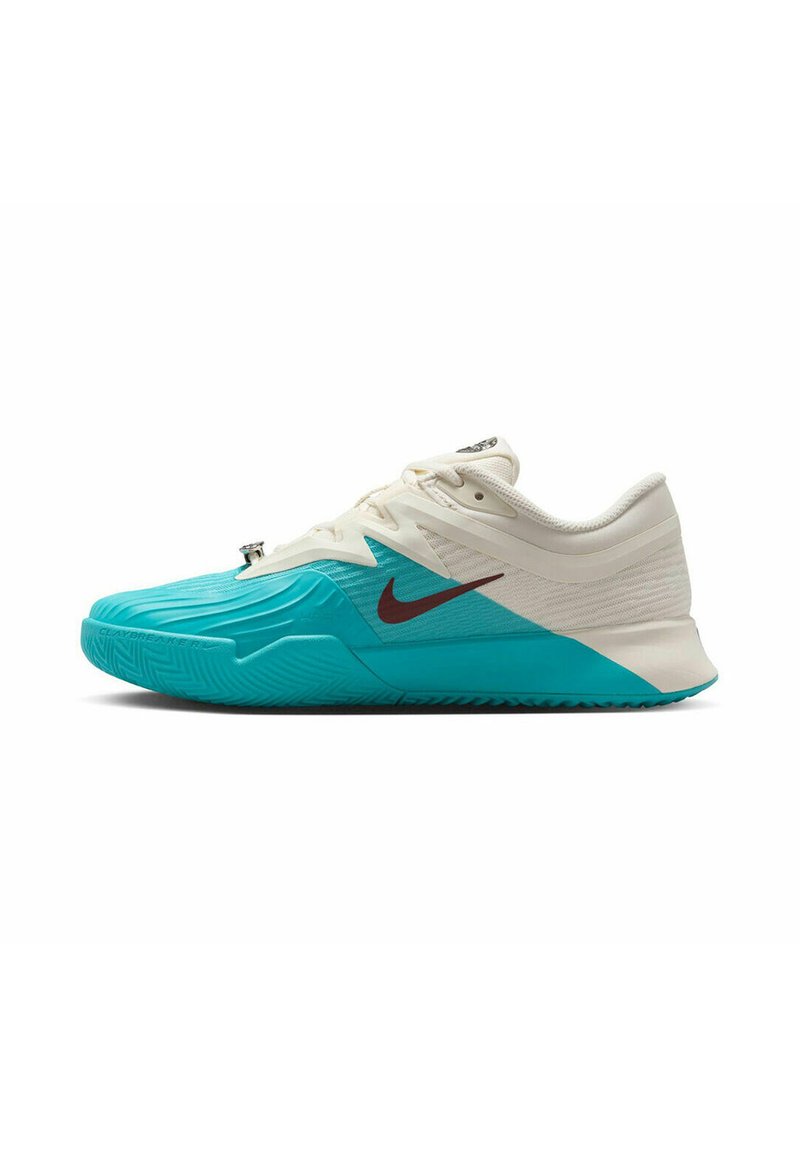 Zapatillas Nike con una parte superior blanca y una suela turquesa, con patrones texturizados y un acento de logo rojo oscuro en el lado.