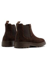 Brązowe zamszowe botki Chelsea z elastycznymi bocznymi panelami, uchwytami oraz trwałymi gumowymi podeszwami o wytrzymałym wzorze bieżnika.